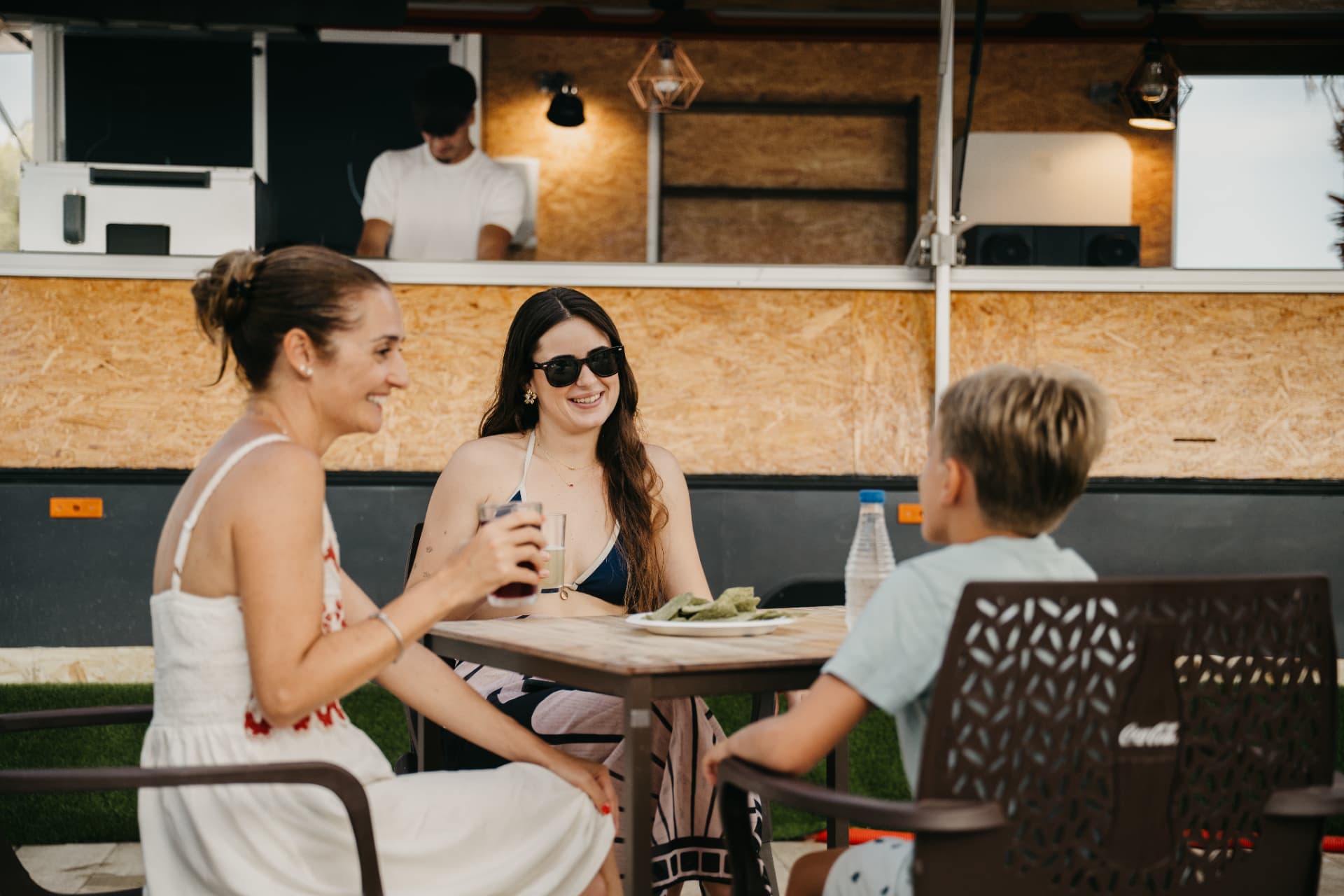 Familia compartiendo bebidas y aperitivos junto al food truck