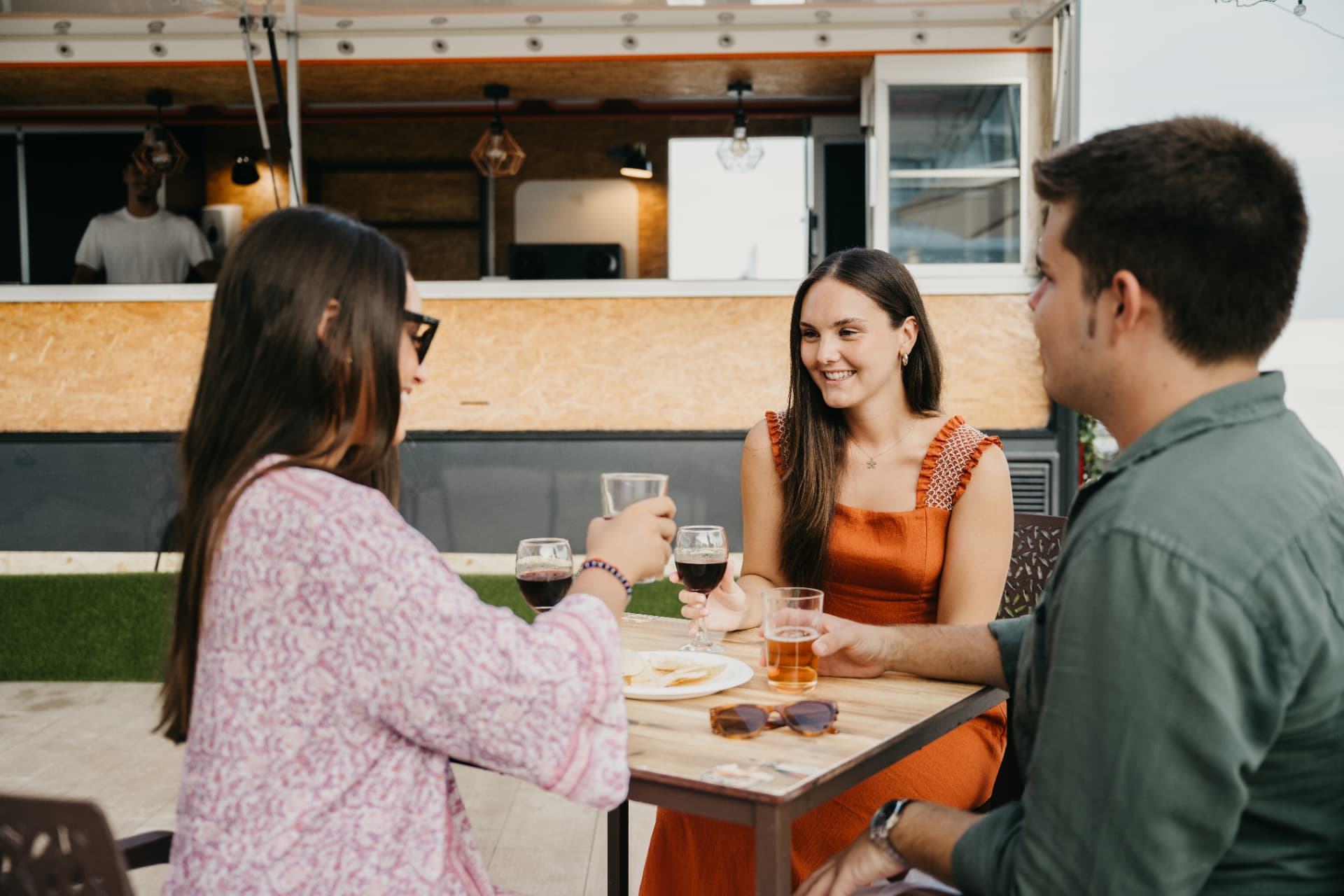 Amigos compartiendo mesa junto al food truck